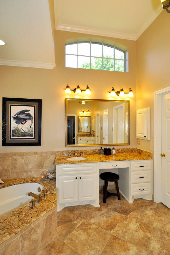 Exempel på ett stort klassiskt en-suite badrum, med ett undermonterad handfat, luckor med upphöjd panel, vita skåp, en jacuzzi, en hörndusch, beige kakel, beige väggar, keramikplattor, travertin golv och laminatbänkskiva