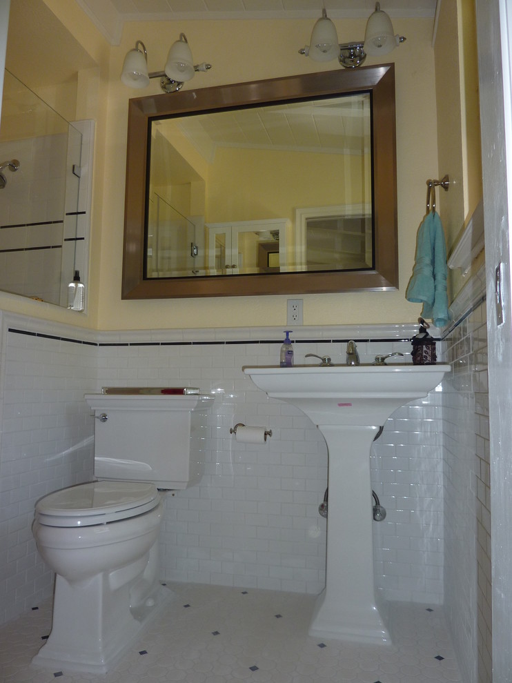 Immagine di una stanza da bagno padronale tradizionale di medie dimensioni con lavabo a colonna, WC a due pezzi, piastrelle bianche, piastrelle in ceramica, pareti gialle, pavimento con piastrelle in ceramica e doccia alcova