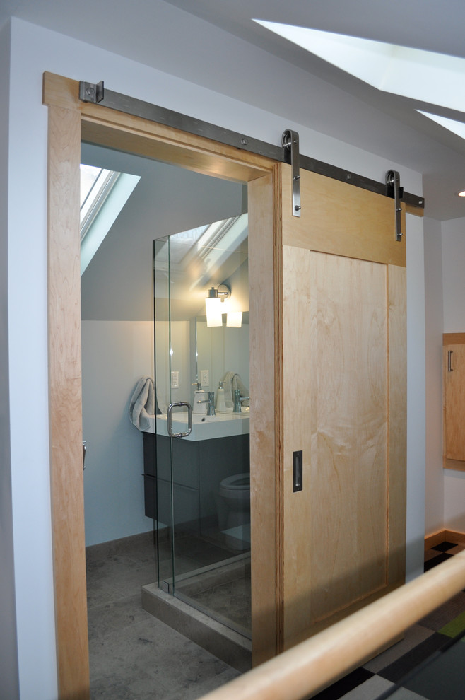 Foto di una stanza da bagno con doccia minimal di medie dimensioni con lavabo integrato, ante lisce, ante grigie, doccia ad angolo, pareti bianche e piastrelle grigie