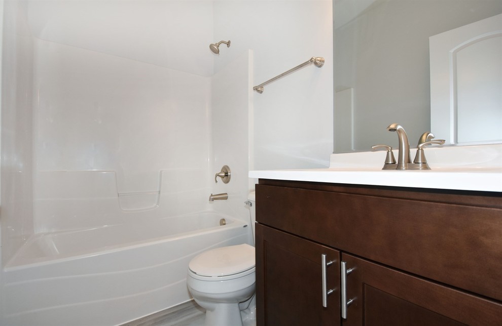 Cette photo montre une salle de bain chic en bois foncé de taille moyenne avec un placard avec porte à panneau encastré, un carrelage gris et des carreaux de céramique.