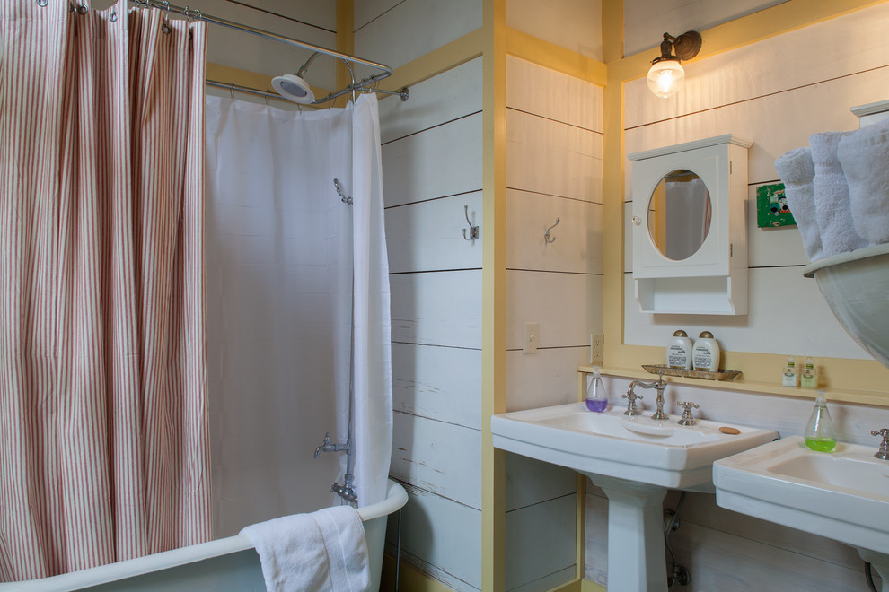 Foto på ett maritimt badrum, med ett fristående badkar och ett piedestal handfat