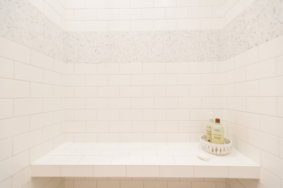 Example of a mid-sized beach style master white tile and porcelain tile concrete floor doorless shower design in Minneapolis with a vessel sink, shaker cabinets, white cabinets, quartz countertops and beige walls