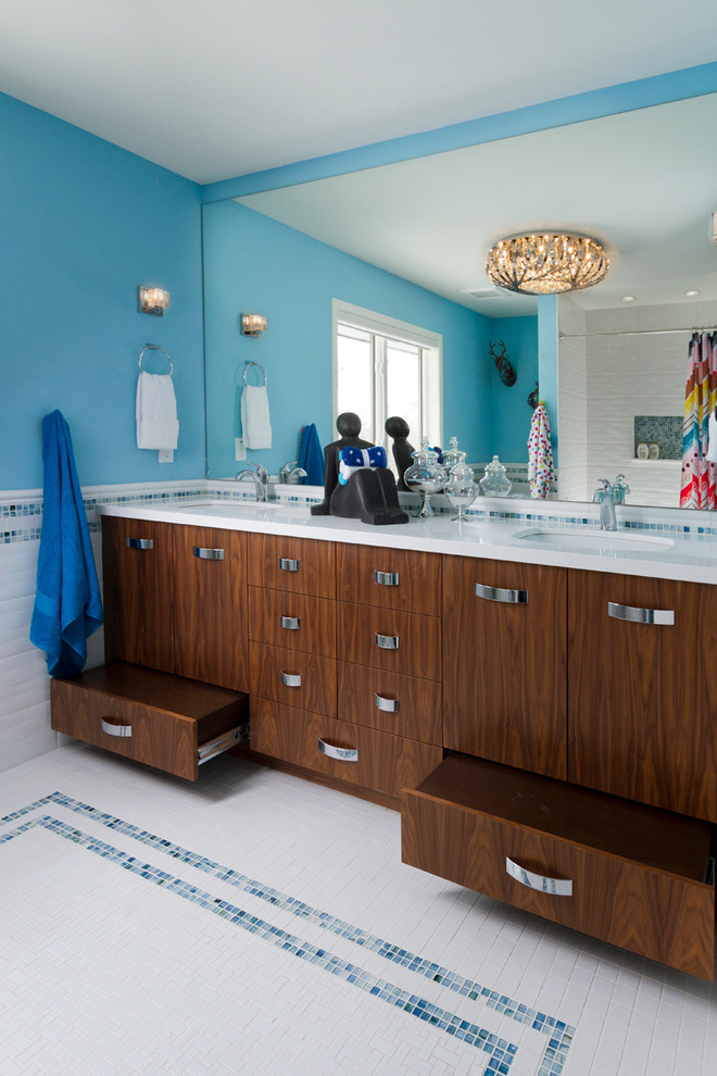 ミネアポリスにある高級な中くらいなコンテンポラリースタイルのおしゃれな子供用バスルーム (アンダーカウンター洗面器、フラットパネル扉のキャビネット、中間色木目調キャビネット、クオーツストーンの洗面台、アルコーブ型浴槽、アルコーブ型シャワー、一体型トイレ	、白いタイル、セラミックタイル、青い壁、セラミックタイルの床) の写真