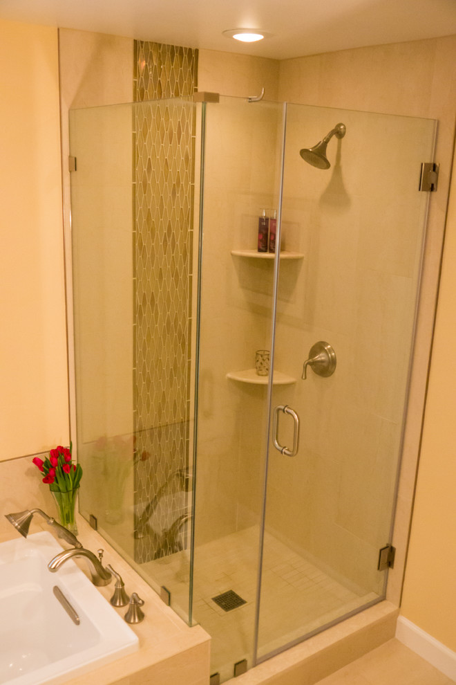 Immagine di una stanza da bagno tradizionale con vasca da incasso, doccia ad angolo, piastrelle beige, piastrelle di vetro, pareti beige e pavimento in gres porcellanato