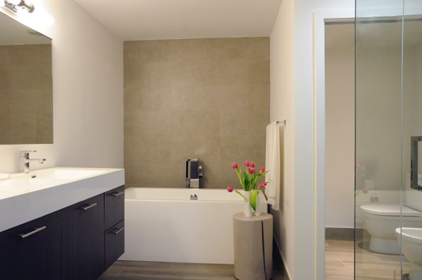 Mittelgroßes Modernes Badezimmer En Suite mit flächenbündigen Schrankfronten, hellbraunen Holzschränken, beigen Fliesen und Porzellanfliesen in New York