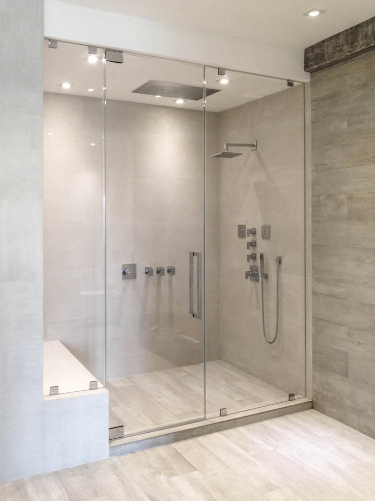 Example of a mid-sized minimalist master gray tile and porcelain tile porcelain tile alcove shower design in Miami with flat-panel cabinets, medium tone wood cabinets, a wall-mount toilet, white walls, an integrated sink and quartz countertops