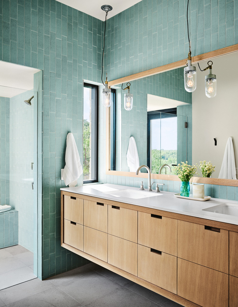 Свежая идея для дизайна: главная ванная комната в современном стиле с плоскими фасадами, фасадами цвета дерева среднего тона, душем без бортиков, синей плиткой, синими стенами и монолитной раковиной - отличное фото интерьера
