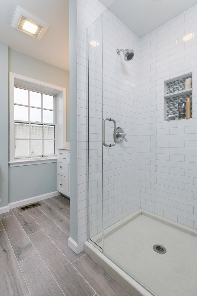 Idéer för ett mellanstort modernt en-suite badrum, med grå väggar, klinkergolv i porslin, brunt golv, en dusch i en alkov, vit kakel, tunnelbanekakel, ett undermonterad handfat, dusch med gångjärnsdörr, skåp i shakerstil, vita skåp och bänkskiva i akrylsten