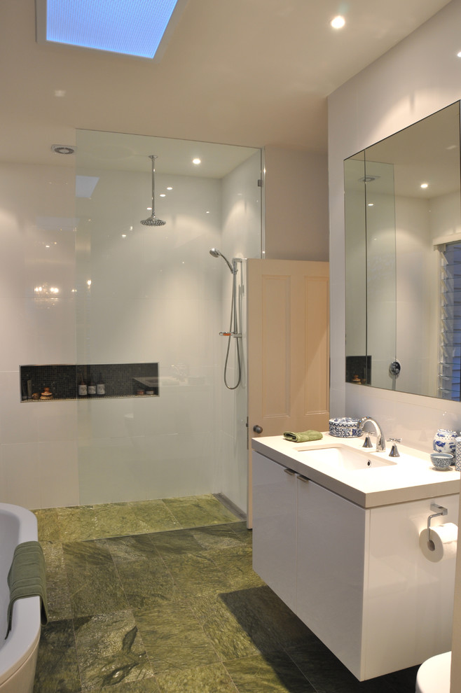 Inspiration for a modern ensuite bathroom in Geelong with flat-panel cabinets, white cabinets, a freestanding bath, a corner shower, a one-piece toilet, white tiles, porcelain tiles, white walls, marble flooring, a submerged sink, green floors and an open shower.