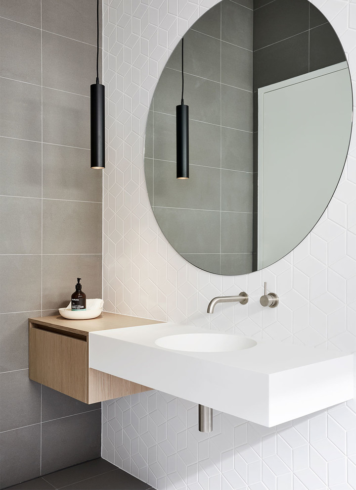 На фото: ванная комната в стиле модернизм с плоскими фасадами, светлыми деревянными фасадами, белыми стенами, подвесной раковиной и серым полом
