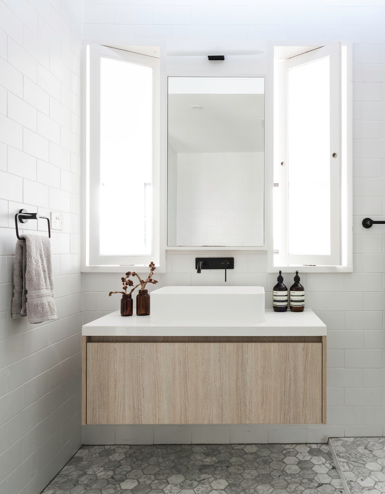 На фото: ванная комната среднего размера в скандинавском стиле с белой плиткой и настольной раковиной