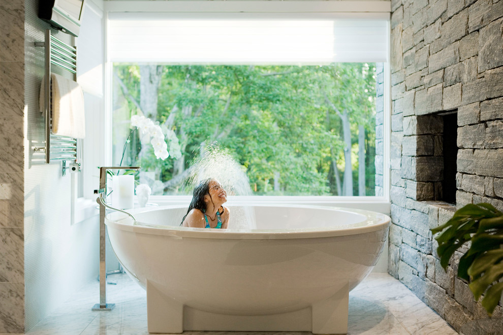 Immagine di una stanza da bagno padronale moderna con vasca freestanding e pavimento in marmo