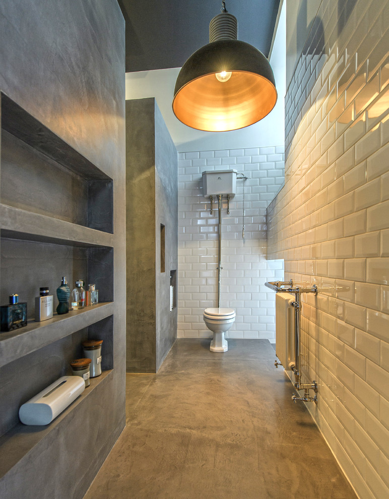 Urban bathroom in Other with a two-piece toilet, white tiles, metro tiles, concrete flooring and grey floors.