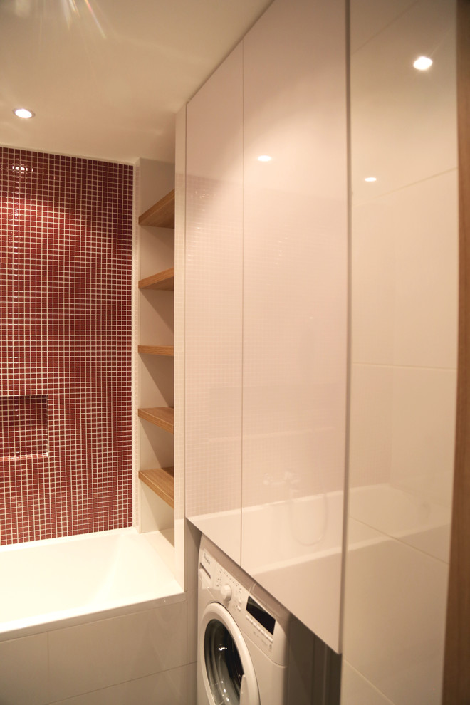 Exempel på ett litet modernt en-suite badrum, med möbel-liknande, skåp i ljust trä, ett badkar i en alkov, en dusch/badkar-kombination, en vägghängd toalettstol, röd kakel, mosaik, vita väggar, klinkergolv i keramik, ett fristående handfat, träbänkskiva och grått golv
