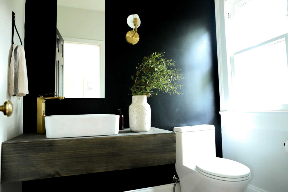 Diseño de cuarto de baño único y flotante contemporáneo pequeño con armarios tipo mueble, puertas de armario de madera oscura, paredes negras, suelo de baldosas de porcelana, aseo y ducha, lavabo integrado, encimera de madera, suelo marrón y encimeras marrones