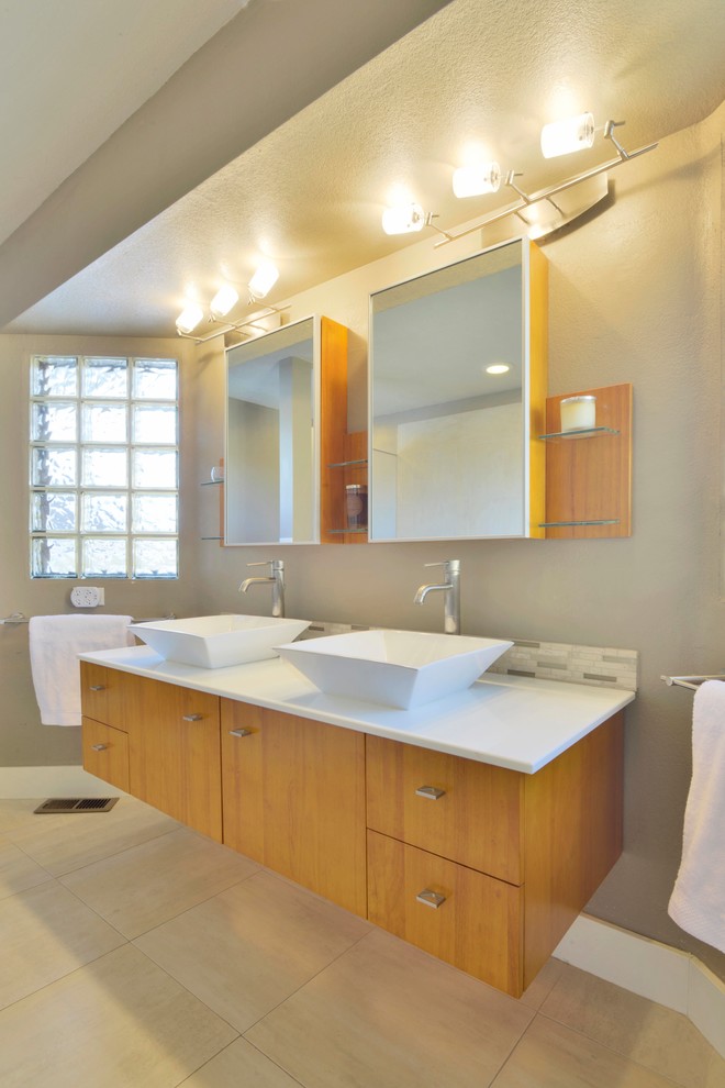 Imagen de cuarto de baño actual con lavabo sobreencimera, armarios con paneles lisos, puertas de armario de madera oscura y paredes grises
