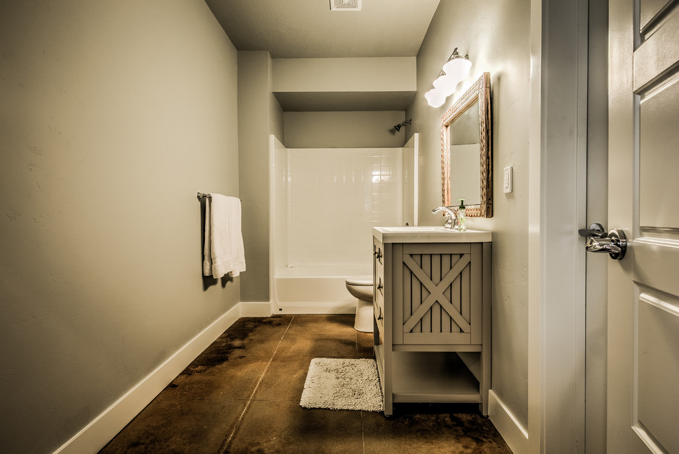 Tub/shower combo - mid-sized farmhouse concrete floor tub/shower combo idea in Boise with a trough sink, light wood cabinets, a one-piece toilet and gray walls