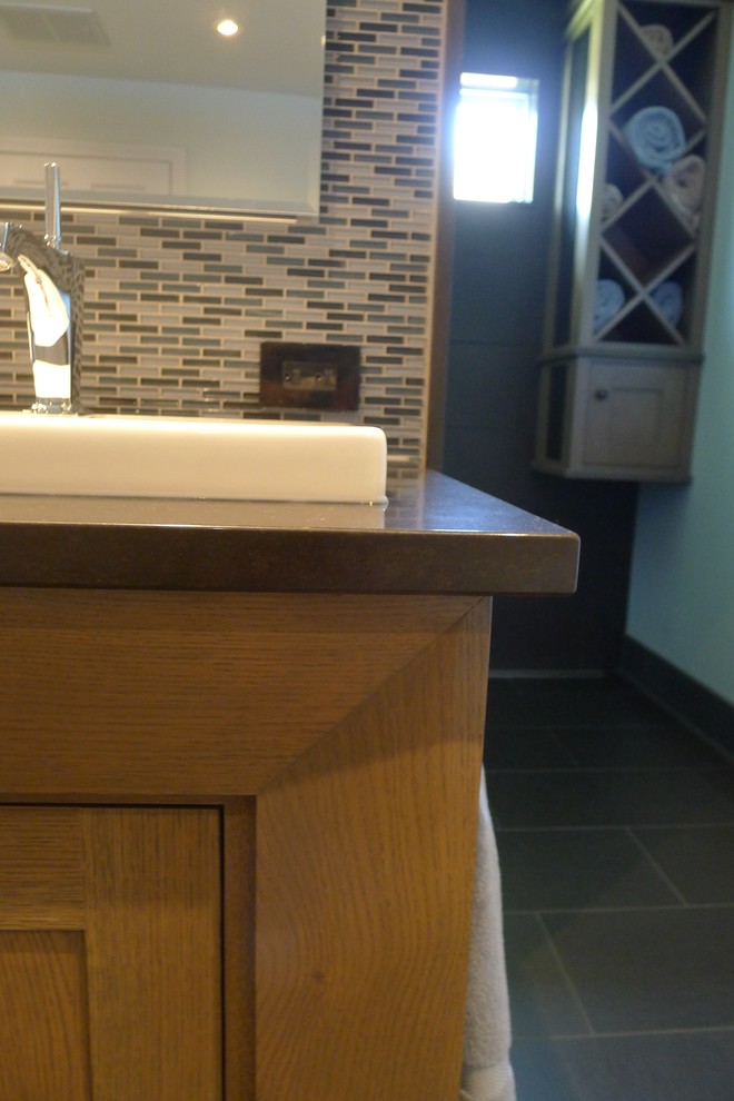 Example of a mid-sized transitional master blue tile and glass sheet ceramic tile doorless shower design in Indianapolis with a drop-in sink, recessed-panel cabinets, gray cabinets, quartzite countertops, a one-piece toilet and blue walls