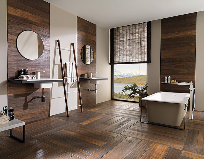 Imagen de cuarto de baño principal contemporáneo grande con bañera exenta, paredes beige, suelo de madera en tonos medios, lavabo suspendido y suelo marrón