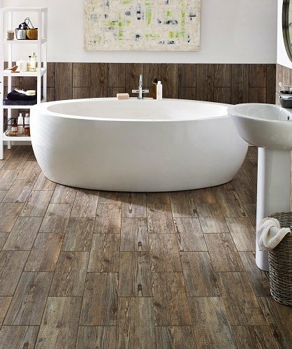 Bild på ett mellanstort funkis en-suite badrum, med ett fristående badkar, brun kakel, vita väggar, vinylgolv, ett piedestal handfat och brunt golv