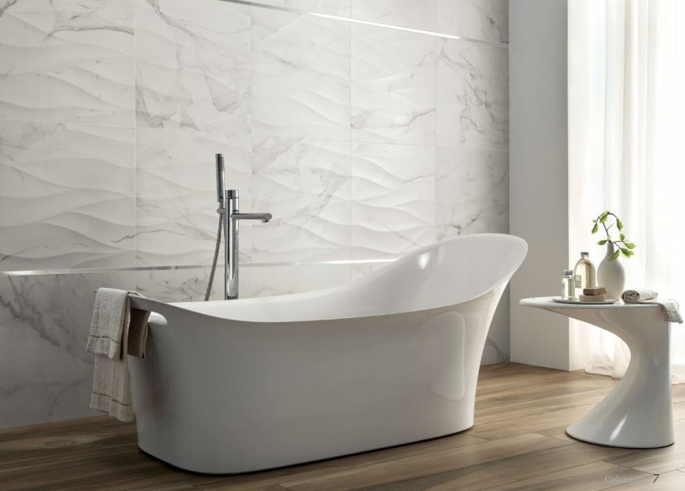 This is an example of a medium sized modern ensuite bathroom in Other with white cabinets, a freestanding bath, white tiles, white walls, medium hardwood flooring and beige floors.