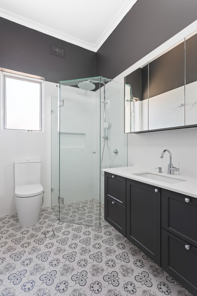 Пример оригинального дизайна: главная ванная комната среднего размера в викторианском стиле с фасадами в стиле шейкер, серыми фасадами, угловым душем, унитазом-моноблоком, белой плиткой, керамической плиткой, серыми стенами, полом из керамической плитки, врезной раковиной, столешницей из искусственного кварца, синим полом и душем с распашными дверями