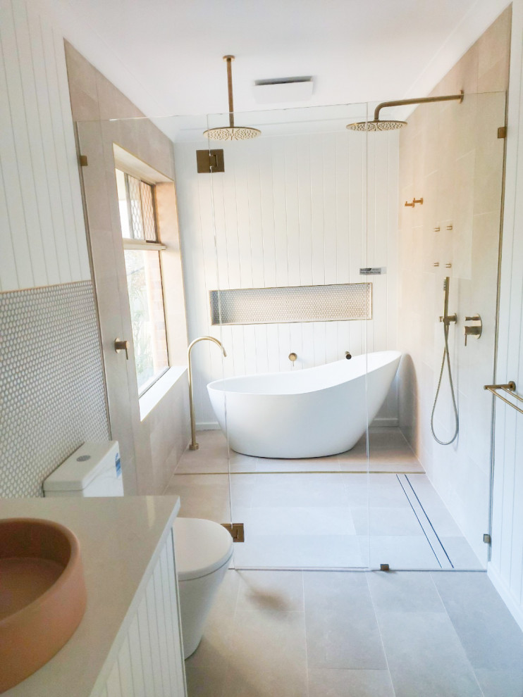 Idées déco pour une grande salle de bain principale moderne avec un placard à porte shaker, des portes de placard blanches, une baignoire indépendante, un espace douche bain, WC à poser, un carrelage blanc, une plaque de galets, un mur blanc, un sol en carrelage de porcelaine, une vasque, un plan de toilette en granite, un sol gris, une cabine de douche à porte battante, un plan de toilette gris, une niche, meuble double vasque, meuble-lavabo sur pied et boiseries.