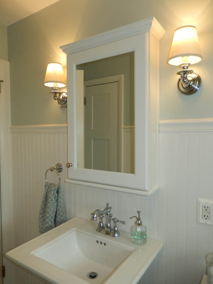 Bild på ett mellanstort maritimt badrum med dusch, med ett piedestal handfat, en dusch i en alkov, en toalettstol med separat cisternkåpa, vit kakel, keramikplattor, blå väggar och klinkergolv i keramik