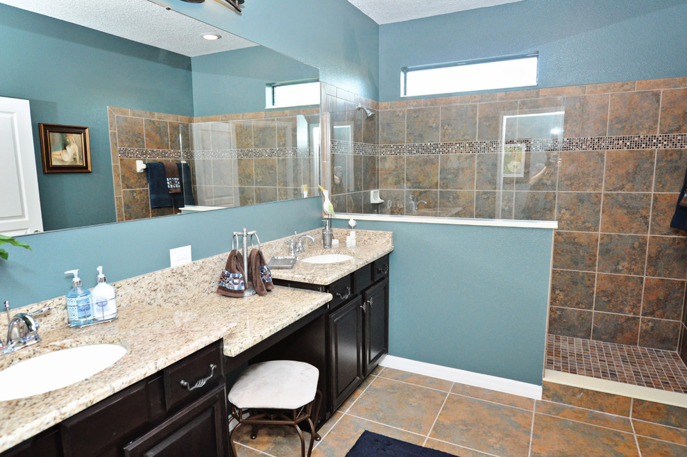 Esempio di una grande stanza da bagno padronale con ante con bugna sagomata, ante in legno bruno, doccia aperta, pareti blu, pavimento con piastrelle in ceramica, lavabo sottopiano e top in granito