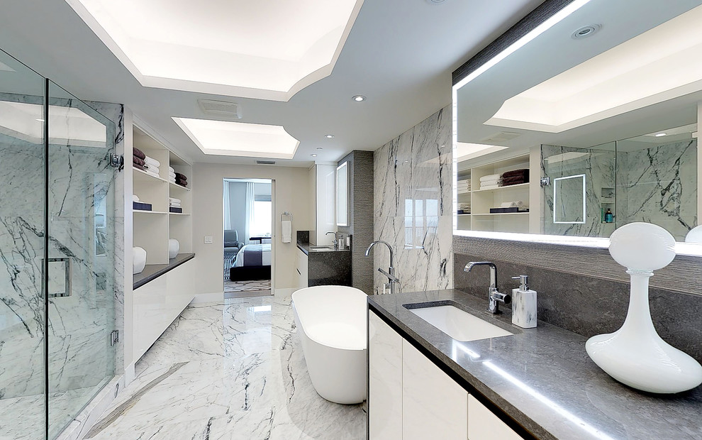 Foto di un'ampia stanza da bagno padronale minimal con ante bianche, vasca freestanding, doccia doppia, pavimento in marmo e porta doccia a battente