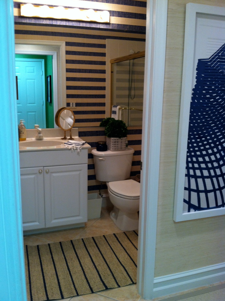 Idées déco pour une salle de bain bord de mer pour enfant avec un lavabo posé, un placard avec porte à panneau surélevé, des portes de placard blanches et un mur bleu.