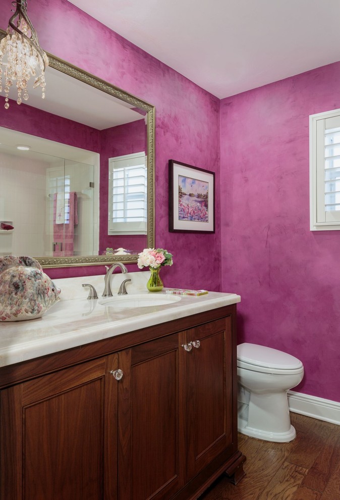 Mittelgroßes Klassisches Duschbad mit Schrankfronten mit vertiefter Füllung, hellbraunen Holzschränken, Duschnische, weißen Fliesen, rosa Wandfarbe, braunem Holzboden, Unterbauwaschbecken und Quarzwerkstein-Waschtisch in Miami