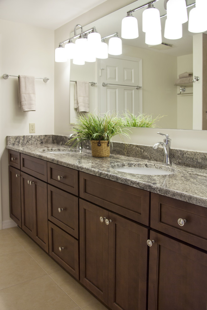 Foto di una stanza da bagno classica di medie dimensioni con ante con riquadro incassato, ante in legno bruno, vasca/doccia e top in granito
