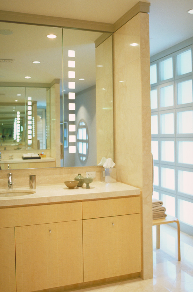 Aménagement d'une salle de bain contemporaine en bois clair avec un placard à porte plane.