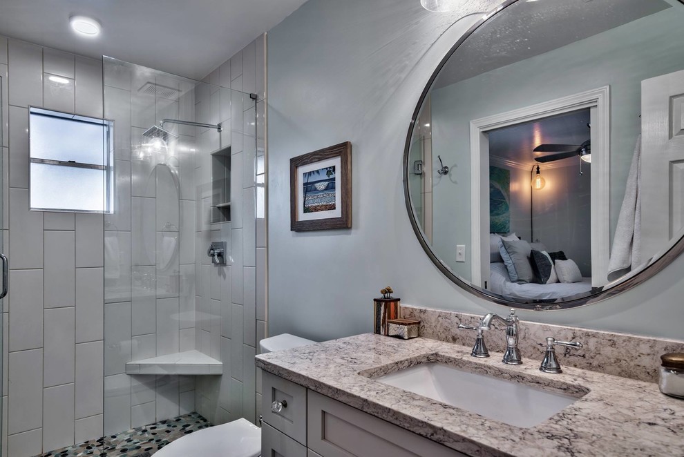 Foto di una stanza da bagno stile marino con piastrelle grigie, piastrelle in ceramica, pavimento con piastrelle in ceramica, pavimento grigio e porta doccia a battente