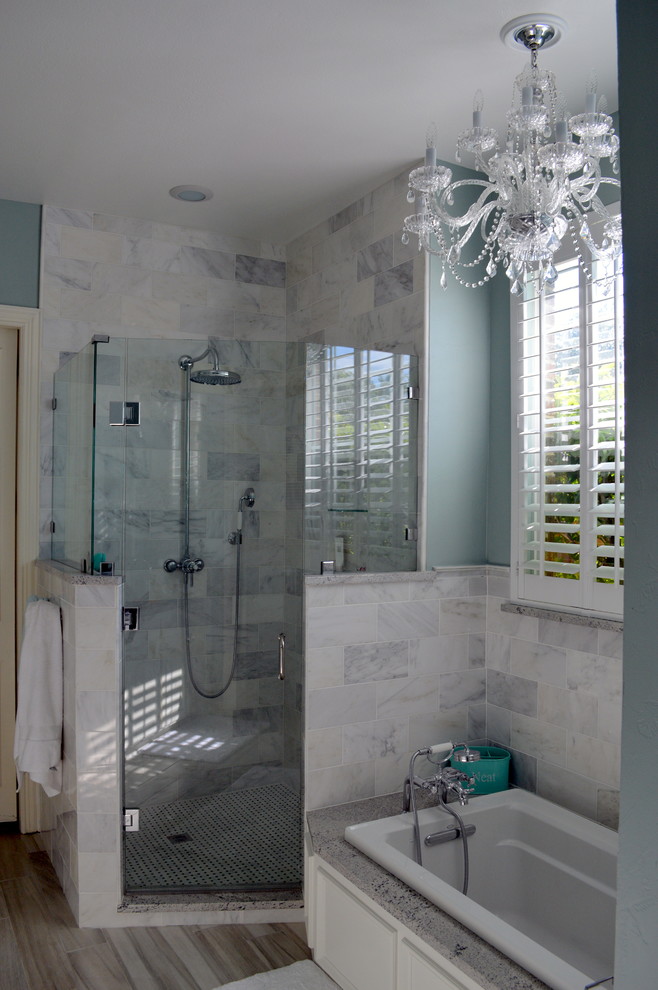 Contemporary ensuite bathroom in Dallas with a submerged sink, flat-panel cabinets, white cabinets, granite worktops, a built-in bath, a corner shower, white tiles, stone tiles, blue walls and porcelain flooring.