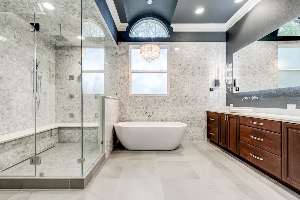 Design ideas for a large contemporary ensuite bathroom in Dallas with raised-panel cabinets, dark wood cabinets, a freestanding bath, a corner shower, a two-piece toilet, grey tiles, marble tiles, grey walls, ceramic flooring, a vessel sink, solid surface worktops, grey floors and a hinged door.