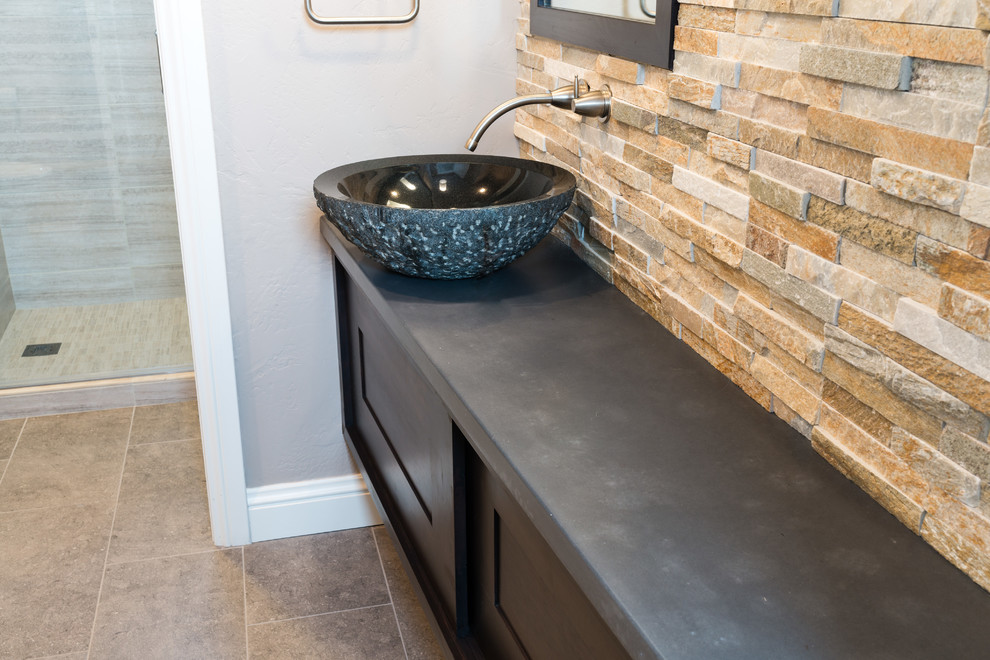 Inspiration for a medium sized contemporary bathroom in Denver with a vessel sink, dark wood cabinets, engineered stone worktops and stone tiles.