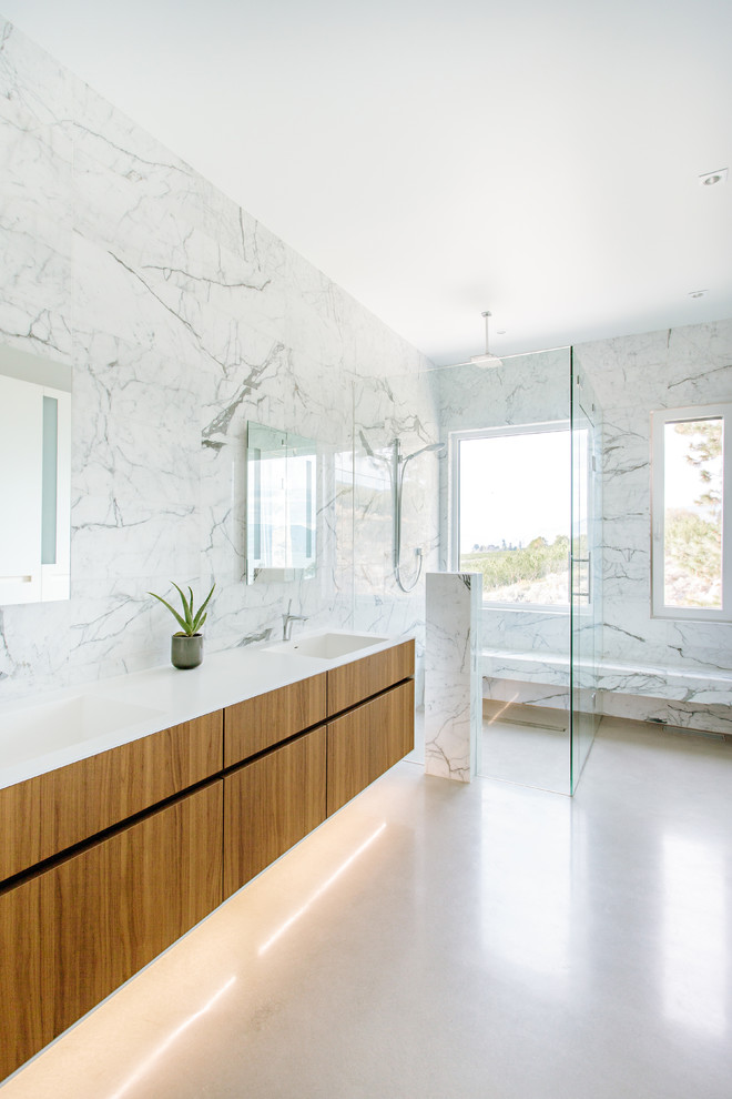 Cette photo montre une salle de bain tendance en bois brun avec un placard à porte plane, une douche d'angle, un carrelage blanc, du carrelage en marbre, un lavabo intégré, un sol blanc et une cabine de douche à porte battante.