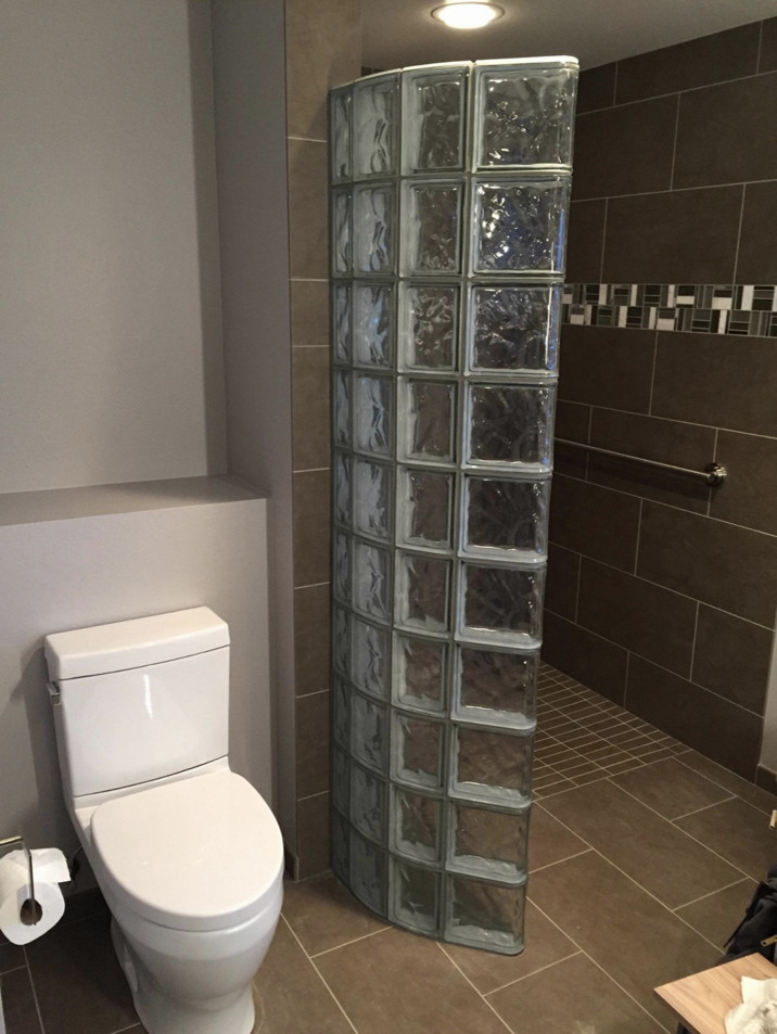 Idéer för att renovera ett mellanstort funkis en-suite badrum, med släta luckor, skåp i ljust trä, ett platsbyggt badkar, en kantlös dusch, en toalettstol med separat cisternkåpa, grå kakel, porslinskakel, grå väggar, klinkergolv i porslin och ett integrerad handfat