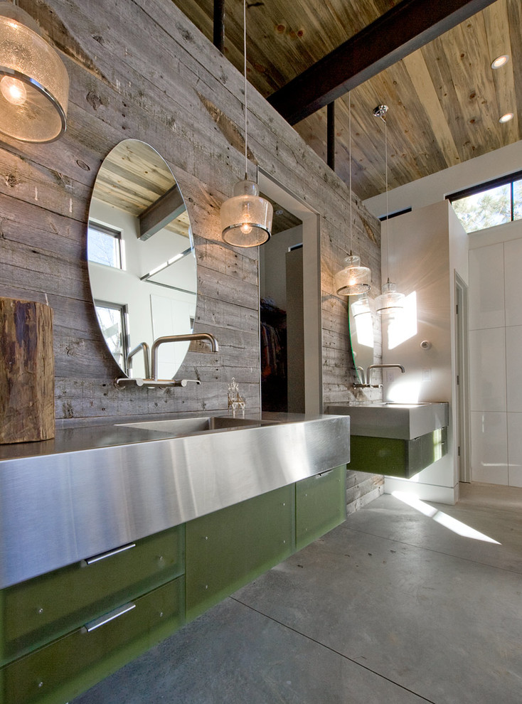 На фото: ванная комната в стиле кантри с монолитной раковиной, плоскими фасадами, зелеными фасадами, столешницей из нержавеющей стали и бетонным полом с
