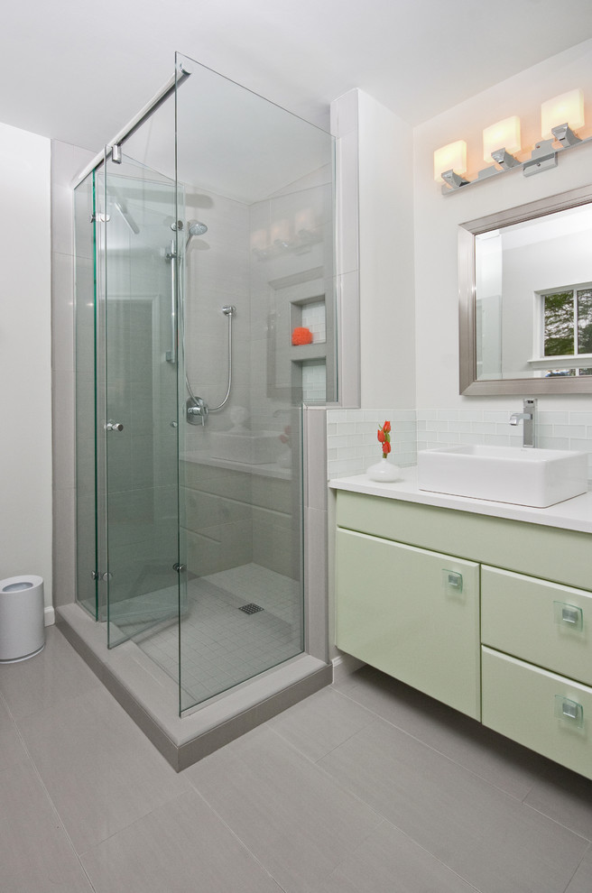 На фото: ванная комната в стиле неоклассика (современная классика) с настольной раковиной, зелеными фасадами, душем в нише и серой плиткой с