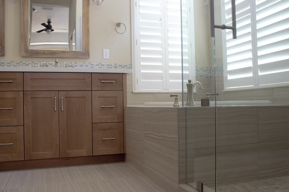 Aménagement d'une salle de bain principale bord de mer en bois clair de taille moyenne avec un placard à porte shaker, une baignoire d'angle, un carrelage gris, mosaïque, un sol en galet, un lavabo posé et un plan de toilette en quartz modifié.