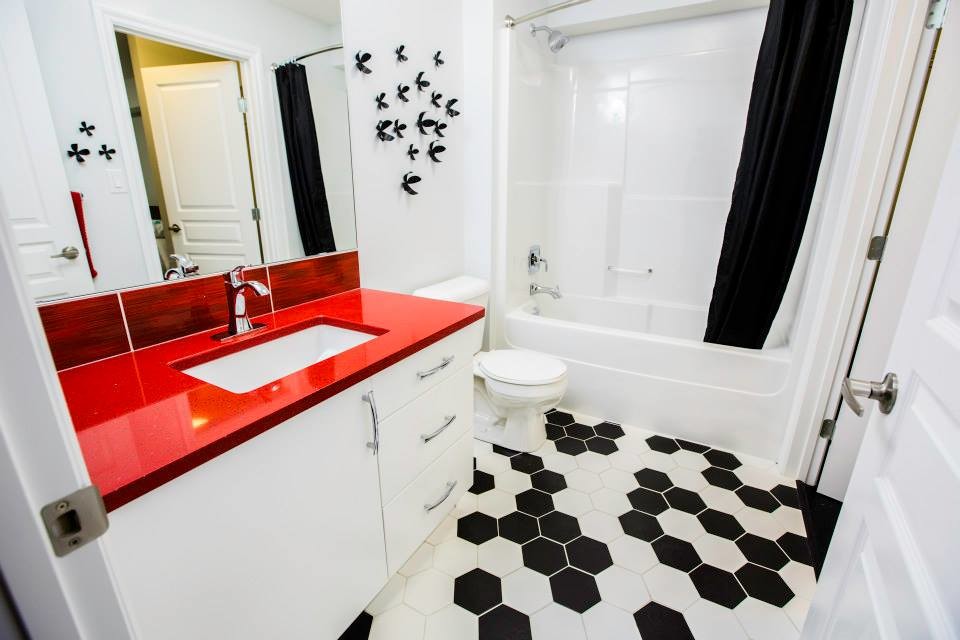Idéer för att renovera ett funkis badrum, med släta luckor, vita skåp, bänkskiva i kvarts, keramikplattor, klinkergolv i keramik, ett undermonterad handfat och svart och vit kakel