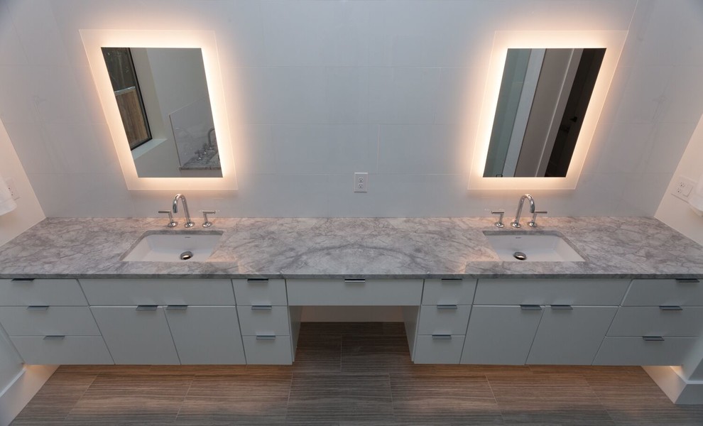 Foto di una stanza da bagno moderna con ante lisce, ante bianche, pareti bianche, pavimento in gres porcellanato, lavabo sottopiano, top in marmo, pavimento marrone, piastrelle bianche e piastrelle in ceramica