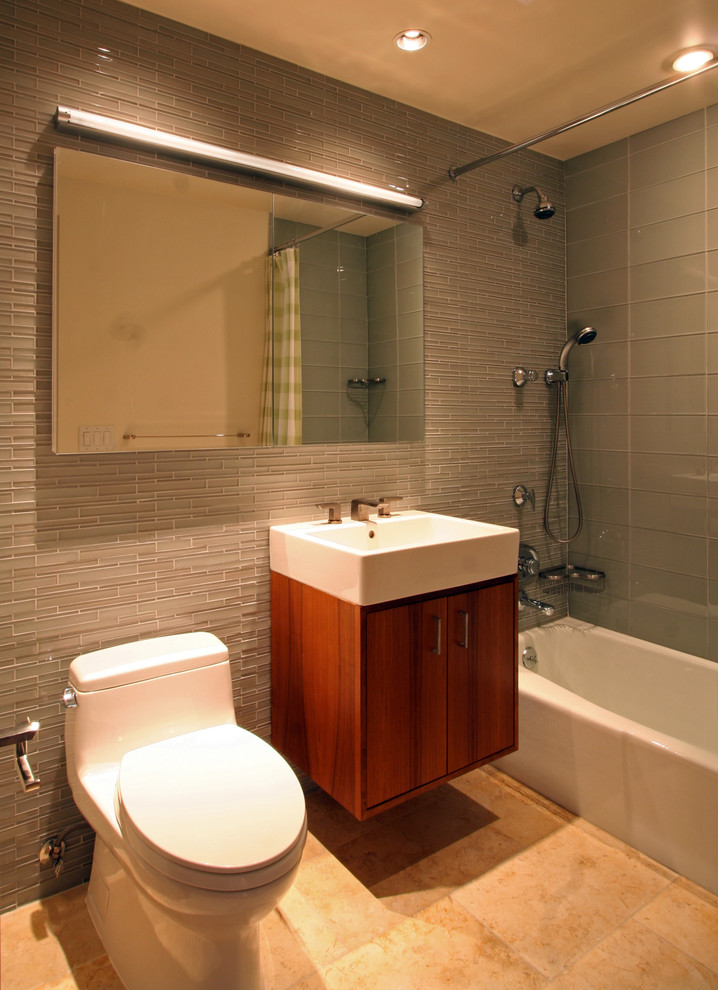 Idéer för att renovera ett mellanstort funkis badrum med dusch, med ett integrerad handfat, släta luckor, skåp i mörkt trä, ett platsbyggt badkar, en dusch/badkar-kombination, en toalettstol med hel cisternkåpa, beige väggar och klinkergolv i porslin