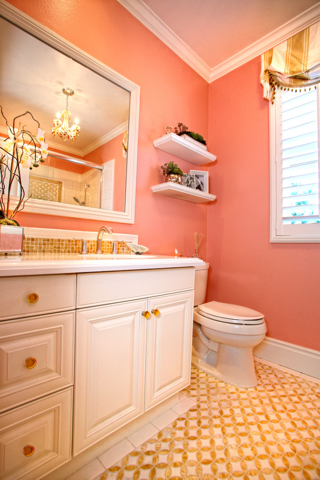 Cette photo montre une salle de bain chic de taille moyenne pour enfant avec un lavabo encastré, un placard avec porte à panneau surélevé, des portes de placard blanches, un plan de toilette en onyx, une baignoire posée, un combiné douche/baignoire, WC séparés, un carrelage blanc, mosaïque, un mur jaune et un sol en marbre.