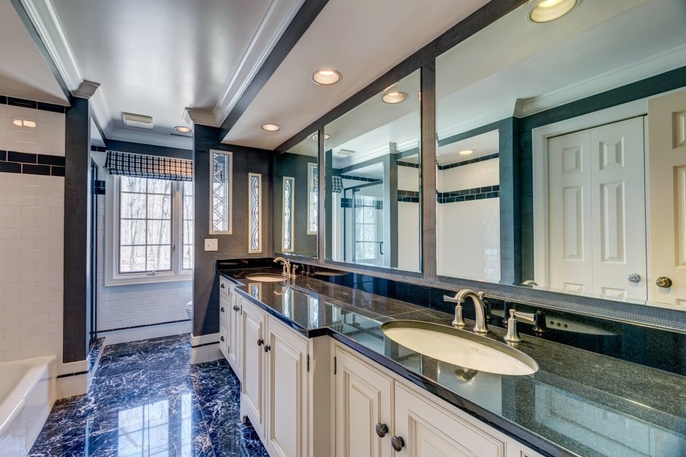 Classic bathroom in Cleveland with a submerged sink, raised-panel cabinets, white cabinets, granite worktops, a shower/bath combination, white tiles, metro tiles and marble flooring.