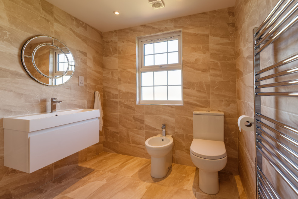 This is an example of a medium sized contemporary shower room bathroom in London with flat-panel cabinets, white cabinets, a one-piece toilet, beige tiles, porcelain tiles, porcelain flooring, a trough sink, beige floors and white worktops.