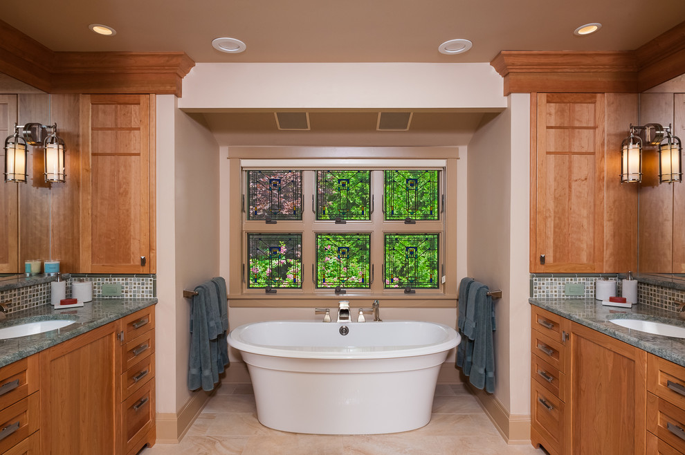 Пример оригинального дизайна: большая главная ванная комната в стиле кантри с врезной раковиной, фасадами в стиле шейкер, фасадами цвета дерева среднего тона, столешницей из гранита, отдельно стоящей ванной, разноцветной плиткой, керамической плиткой, бежевыми стенами, полом из керамогранита и зеленой столешницей